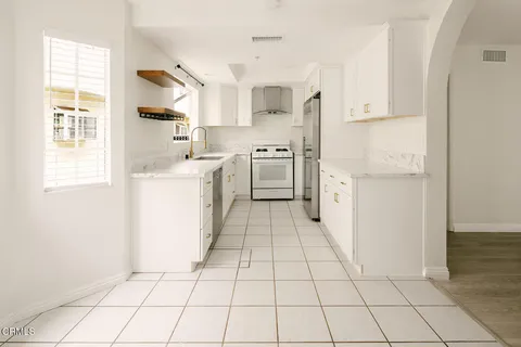 a kitchen with white cabinets a sink and appliances