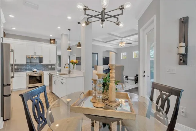a kitchen with a sink dining table and chairs