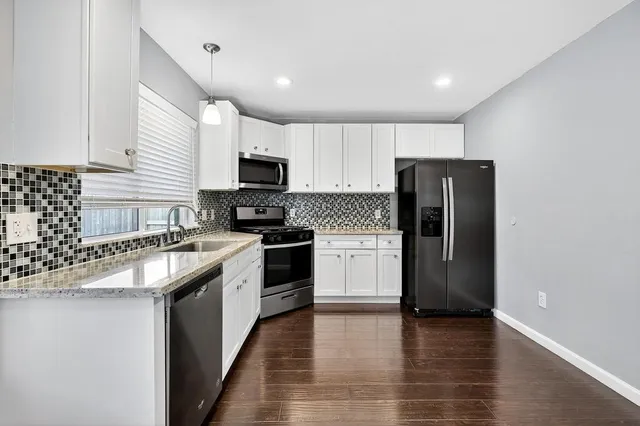 a kitchen with a refrigerator a stove top oven a sink and dishwasher