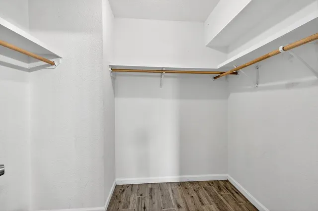 a view of walk in closet with wooden floor