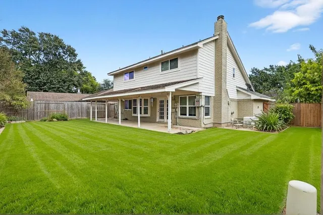 a view of a house with backyard and sitting area