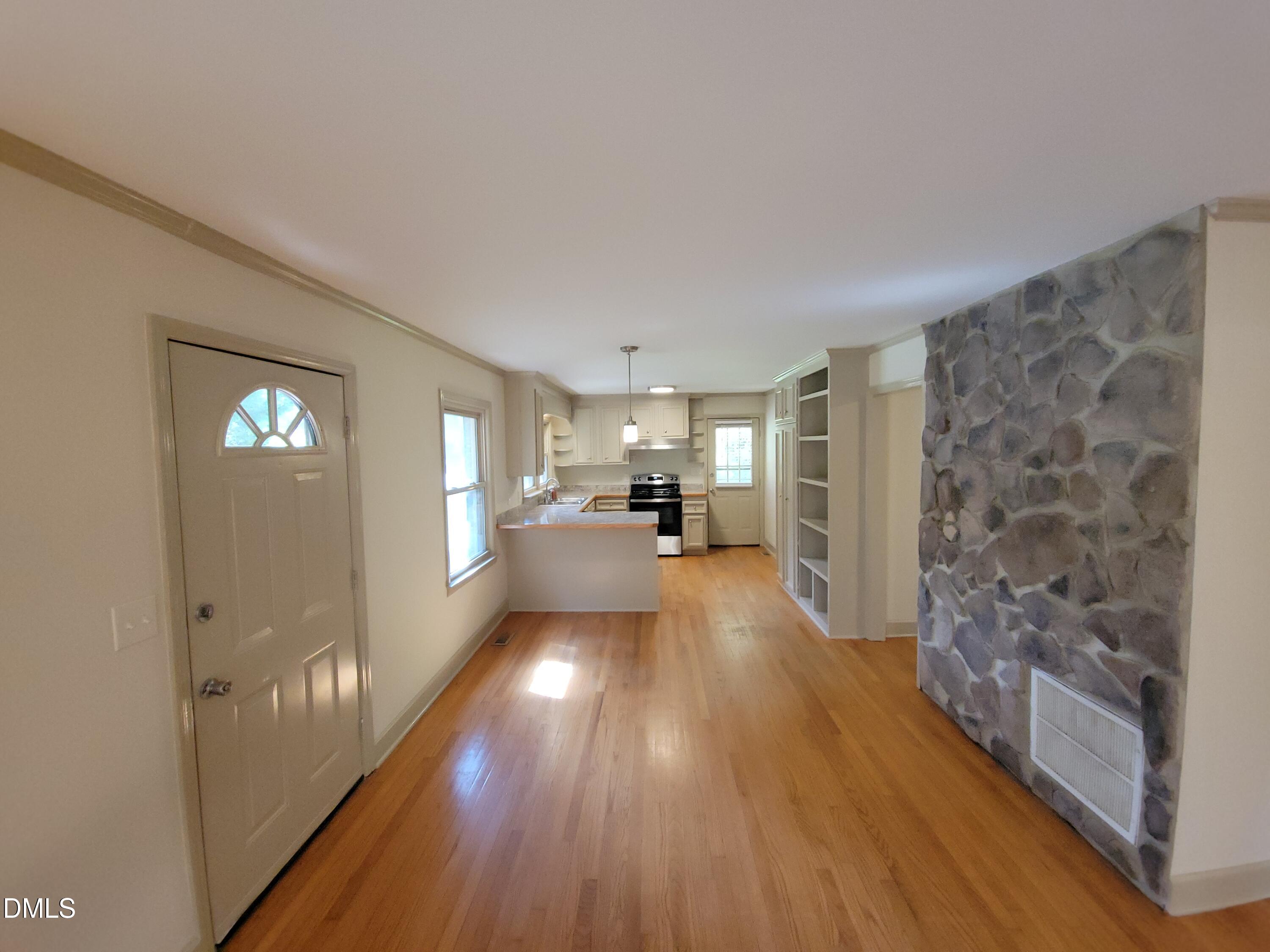 7000 Holly Springs Road Raleigh, NC 27606 - Photo 7 of 24 a view of a living room hardwood floor and a kitchen
