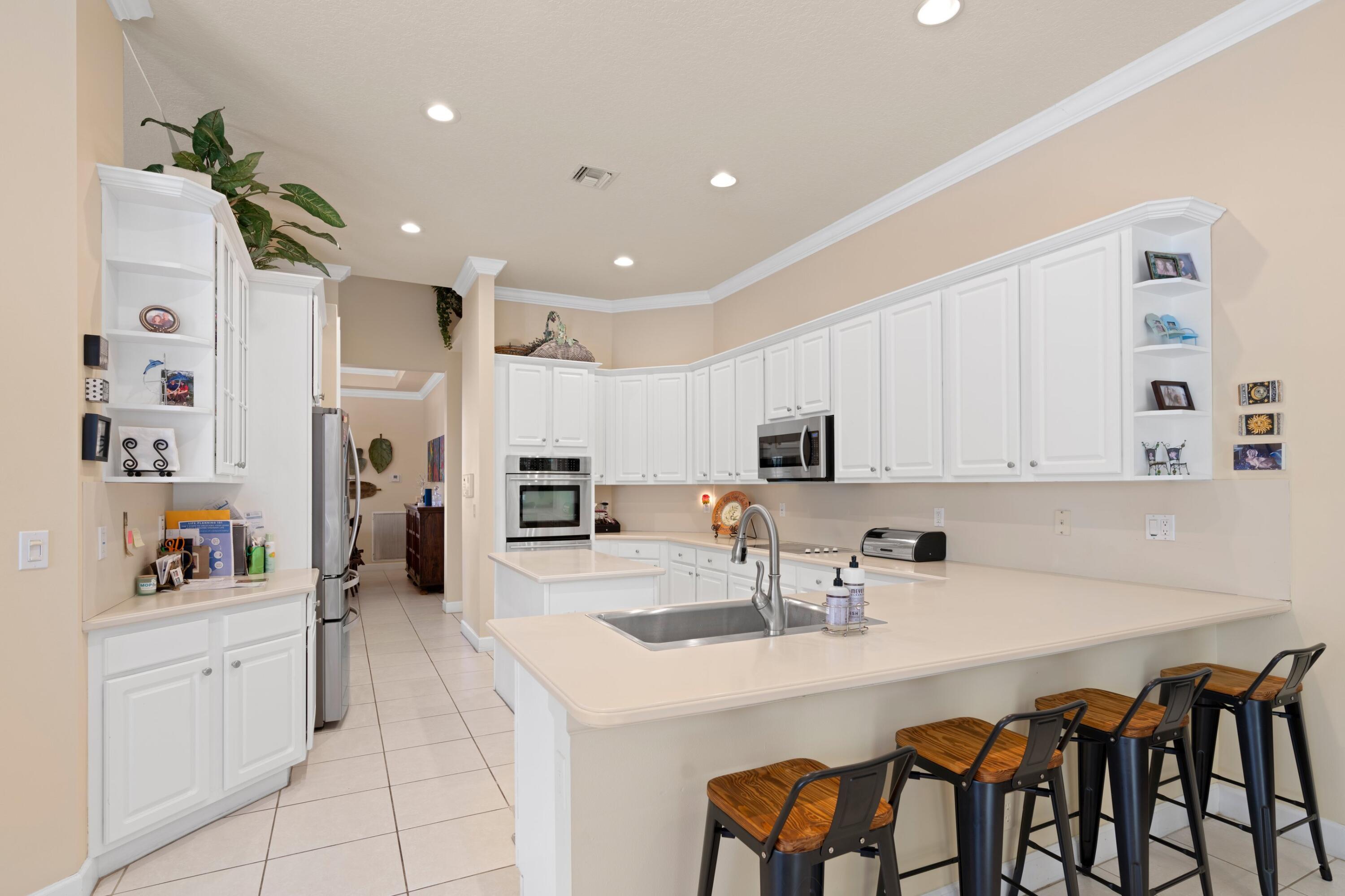 21334 Falls Ridge Way Boca Raton, FL 33428 - Photo 11 of 22 a kitchen with stainless steel appliances a sink a stove a refrigerator and cabinets