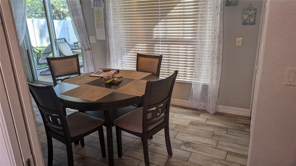 3101 Fallow Road Venice, FL 34293 - Photo 9 of 18 a view of a dining room with furniture and wooden floor