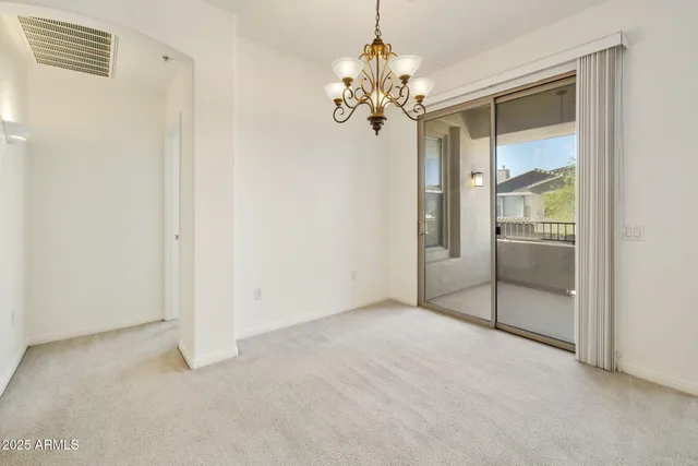an empty room with windows and ceiling fan