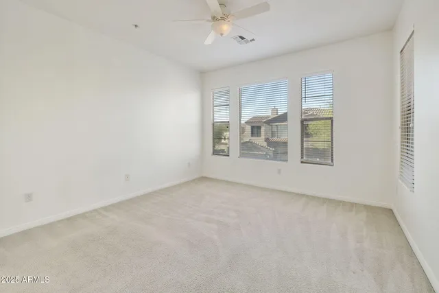 a bedroom with a balcony a bed and a painting on the wall