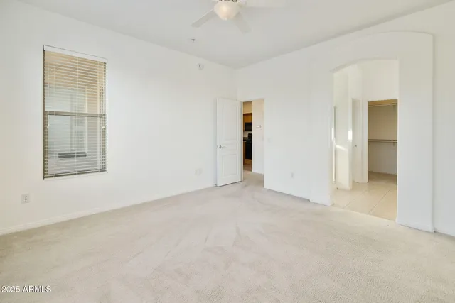 an empty room with chandelier fan