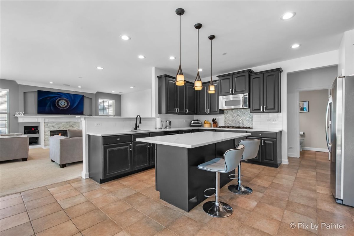 5919 Chatham Drive Hoffman Estates, IL 60192 - Photo 15 of 52 a open kitchen with stainless steel appliances kitchen island granite countertop a sink and cabinets