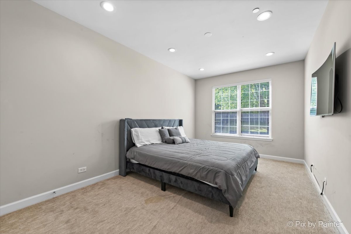 5919 Chatham Drive Hoffman Estates, IL 60192 - Photo 20 of 52 a bed sitting in a spacious bedroom next to a window