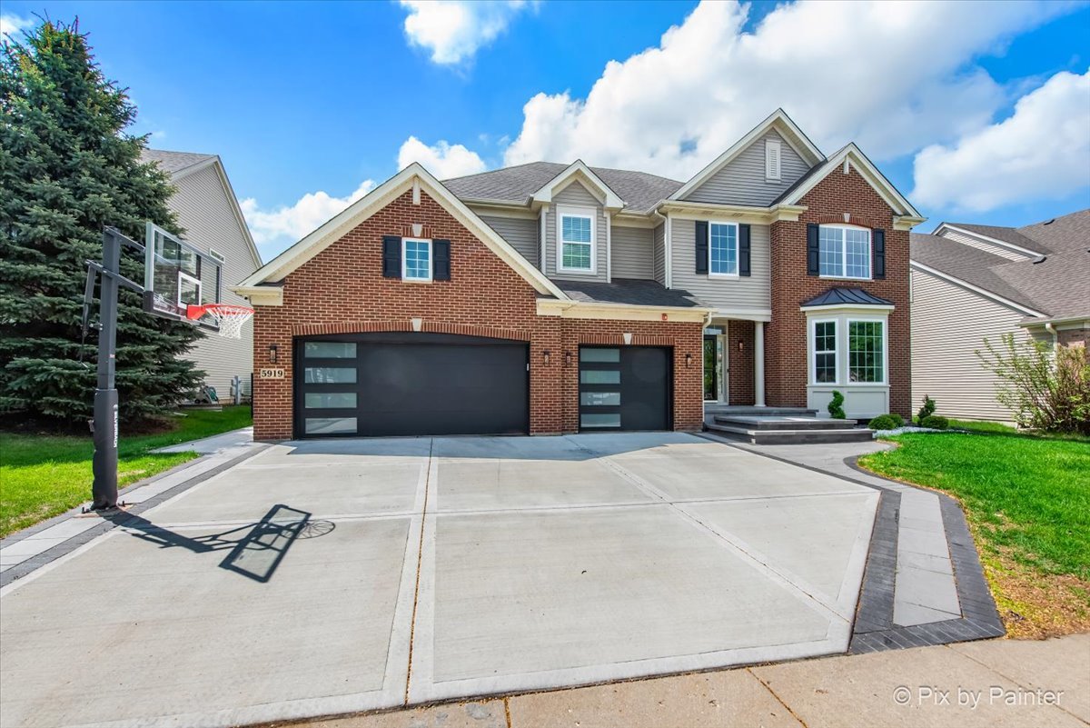 5919 Chatham Drive Hoffman Estates, IL 60192 - Photo 2 of 52 a front view of a house with yard and parking