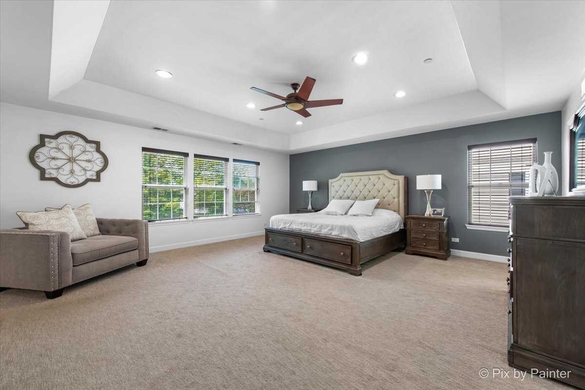 5919 Chatham Drive Hoffman Estates, IL 60192 - Photo 22 of 52 a spacious bedroom with a bed and a chandelier