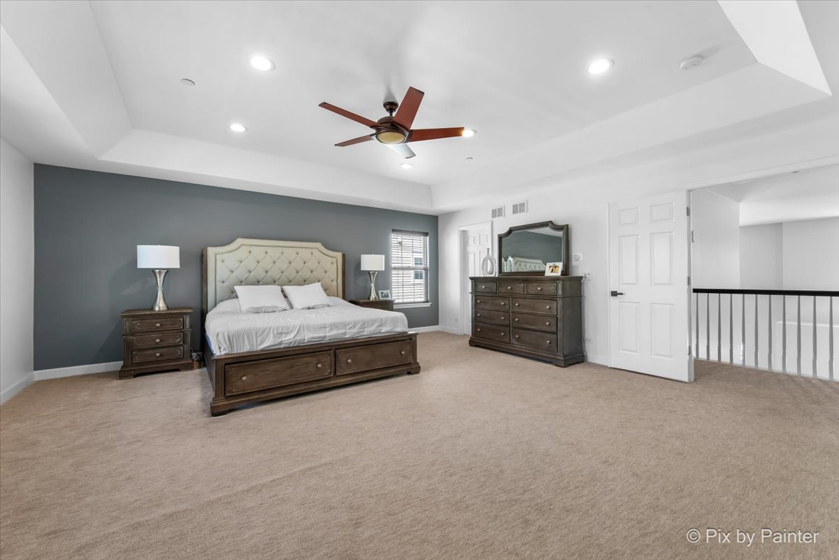 5919 Chatham Drive Hoffman Estates, IL 60192 - Photo 23 of 52 a spacious bedroom with a bed and a chandelier