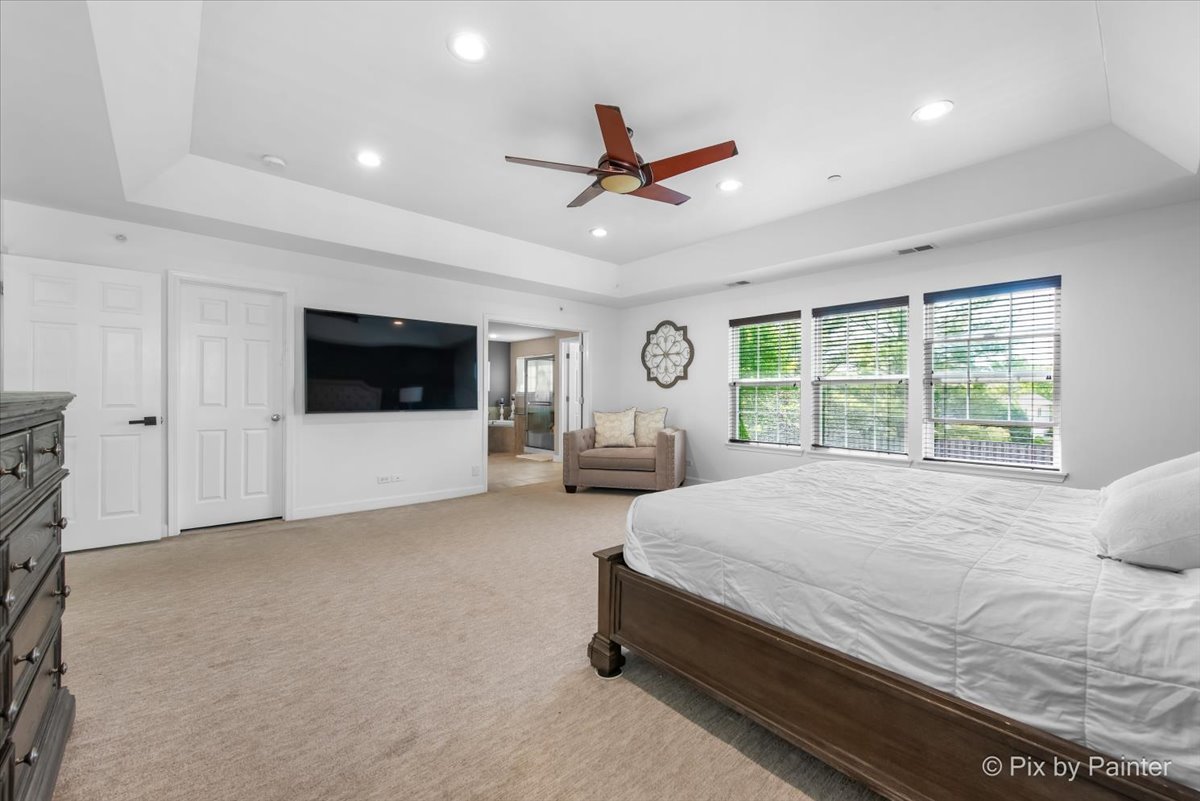 5919 Chatham Drive Hoffman Estates, IL 60192 - Photo 24 of 52 a spacious bedroom with a large bed and a tv