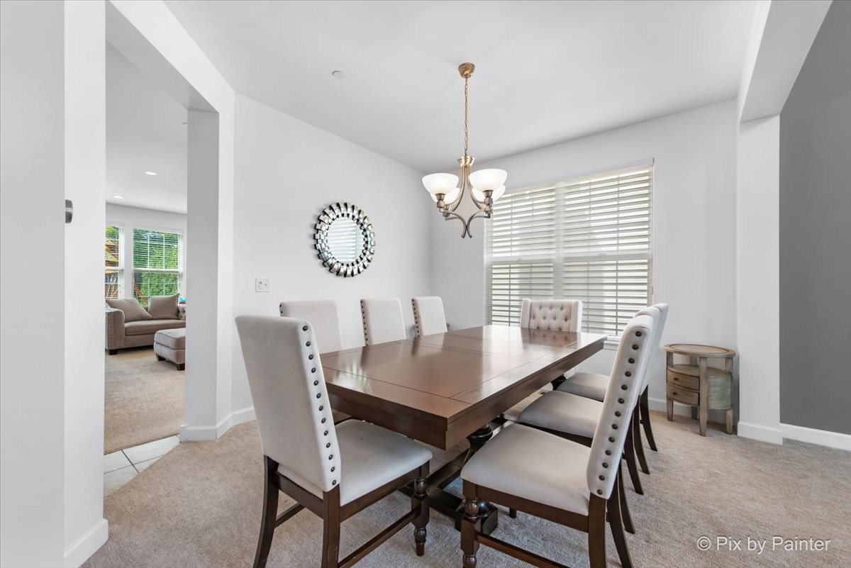 5919 Chatham Drive Hoffman Estates, IL 60192 - Photo 10 of 52 a view of a dining room and livingroom with furniture wooden floor a chandelier