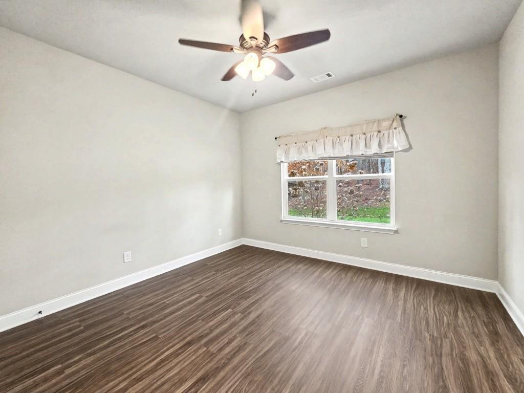 453 Mulberry Rock Road Temple, GA 30179 - Photo 25 of 35 an empty room with wooden floor chandelier fan and windows