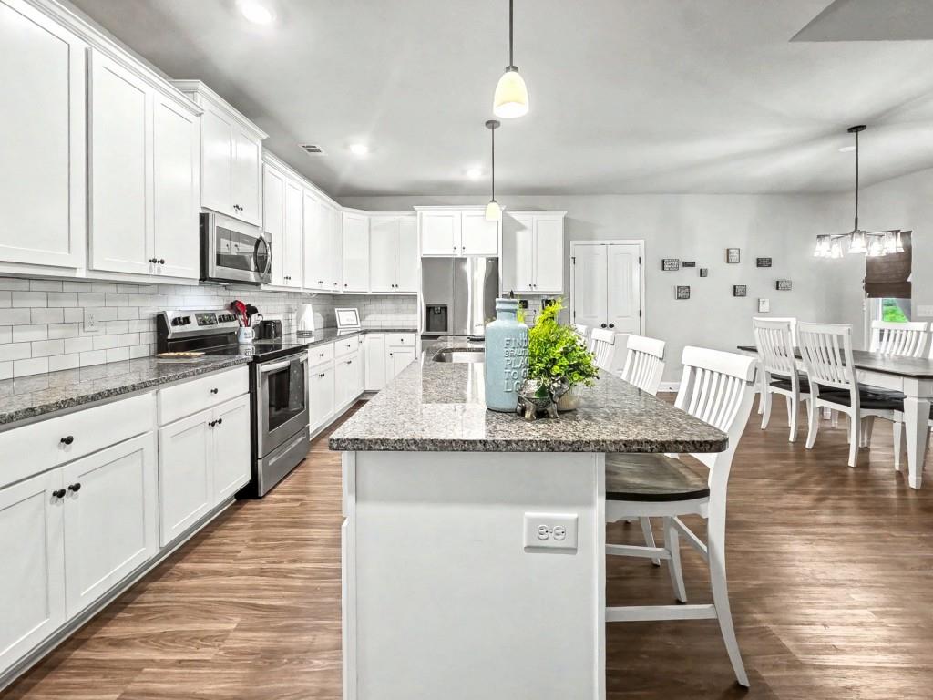 453 Mulberry Rock Road Temple, GA 30179 - Photo 7 of 35 a kitchen with stainless steel appliances kitchen island granite countertop a table chairs and a refrigerator