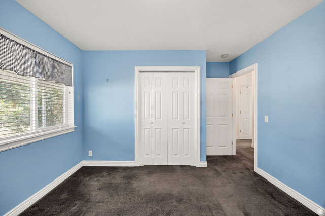 80 North 500 West Logan, UT 84321 - Photo 14 of 36 Carpeted room featuring a white-framed window with blinds, bi-fold closet doors, and light blue wall finishes