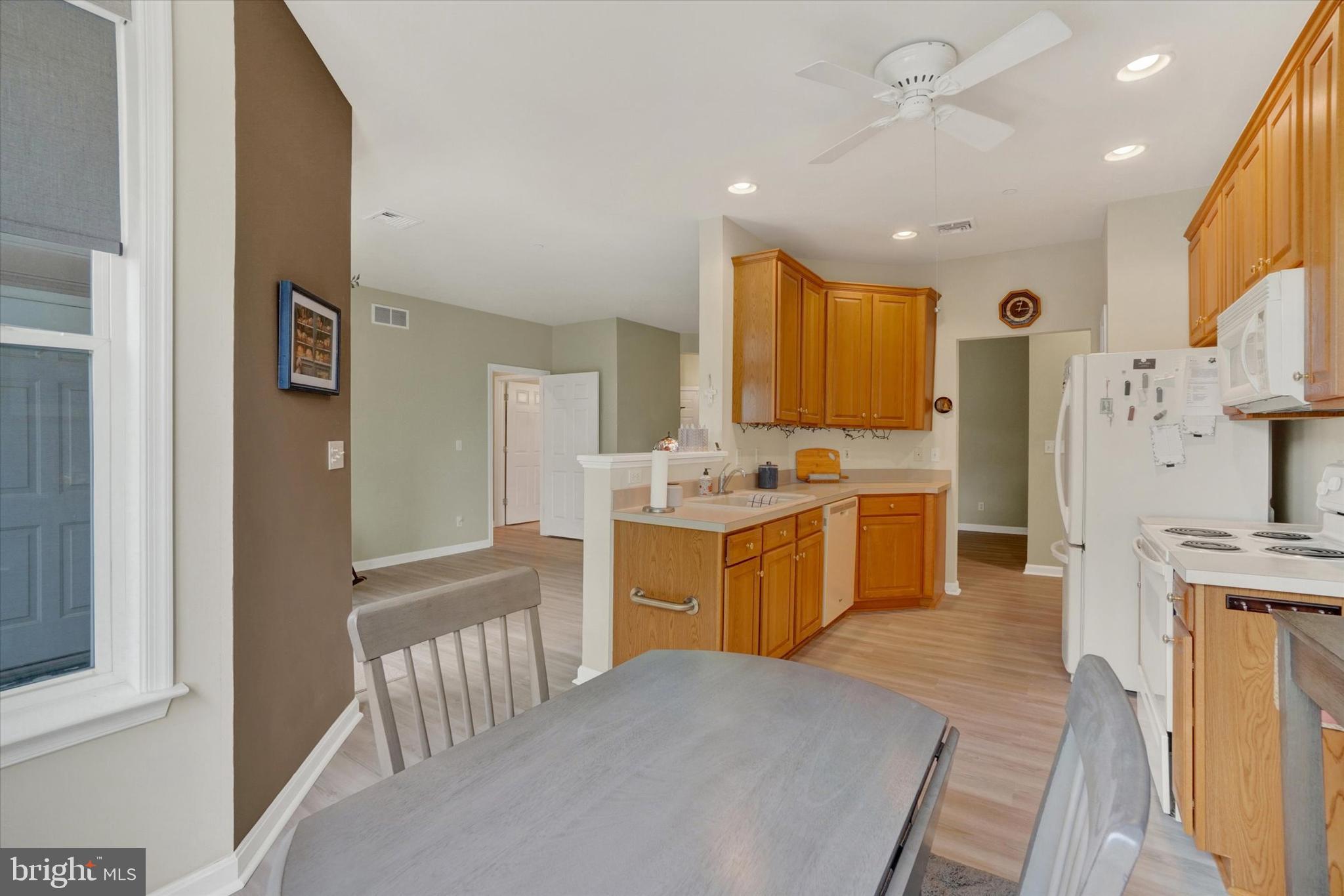 1010 Crest Way, Unit 304 York, PA 17403 - Photo 8 of 24 a large kitchen with a refrigerator a sink dishwasher and white cabinets with wooden floor