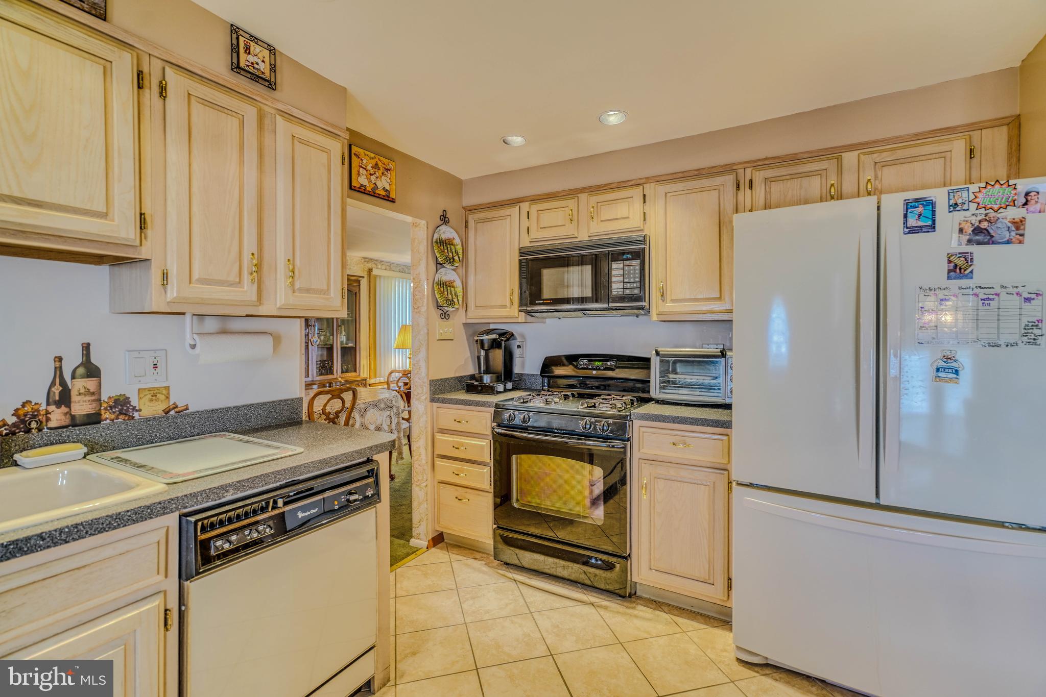 1137 Layton Road Philadelphia, PA 19115 - Photo 20 of 48 a kitchen with stainless steel appliances granite countertop a refrigerator sink stove and white cabinets