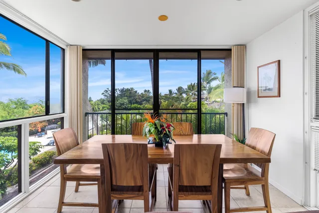 a dining room with furniture large windows and wooden floor