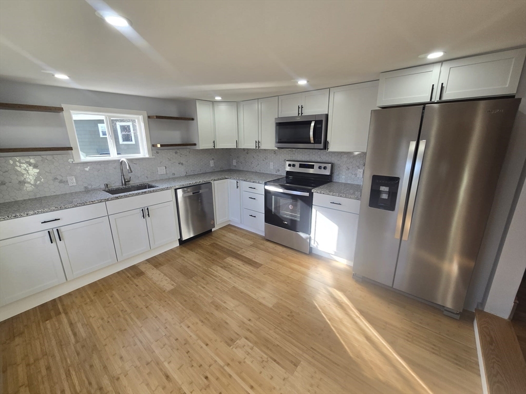 22 Linden Street Reading, MA 01867 - Photo 3 of 32 a kitchen with stainless steel appliances granite countertop a refrigerator sink and stove