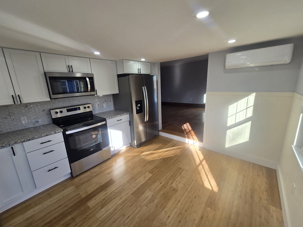22 Linden Street Reading, MA 01867 - Photo 4 of 32 a kitchen with stainless steel appliances a stove a refrigerator a sink a stove white cabinets and wooden floor