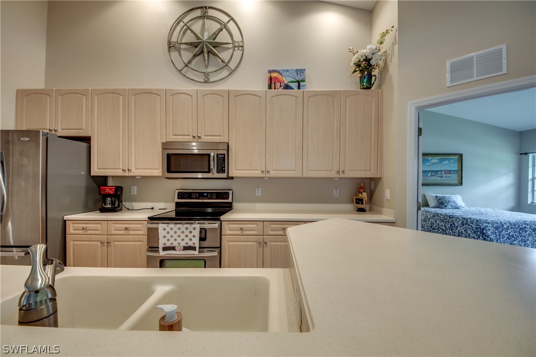 5180 Park Road, Unit 4 Fort Myers, FL 33908 - Photo 6 of 24 a kitchen with a refrigerator a stove a microwave and cabinets
