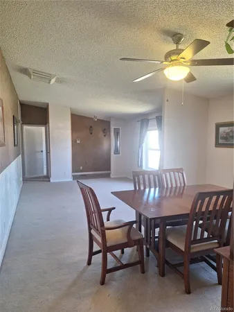 a kitchen with stainless steel appliances a table chairs refrigerator and cabinets