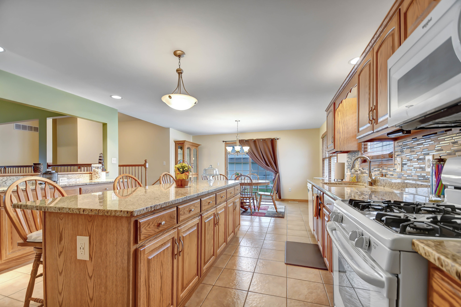 2012 Willow Brook Drive Bourbonnais, IL 60914 - Photo 11 of 33 a kitchen with stainless steel appliances granite countertop a sink a stove and a wooden floors