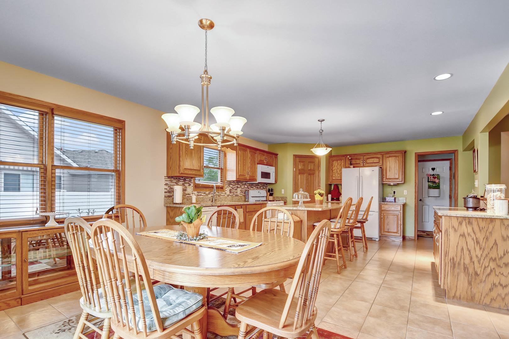 2012 Willow Brook Drive Bourbonnais, IL 60914 - Photo 15 of 33 a view of a dining room with furniture a chandelier and large windows