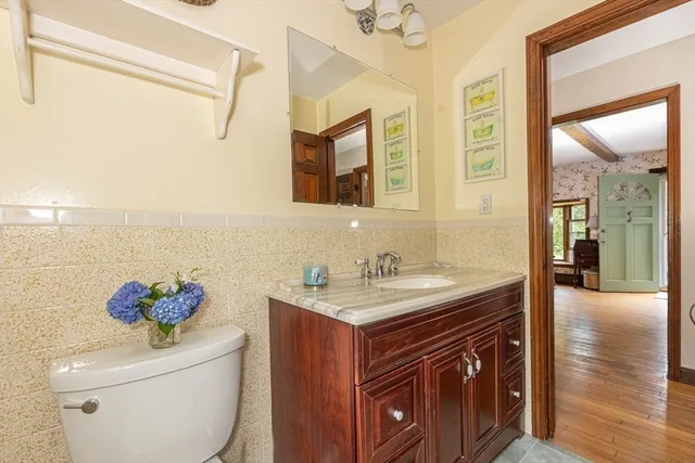 a bathroom with a granite countertop sink a toilet and a mirror