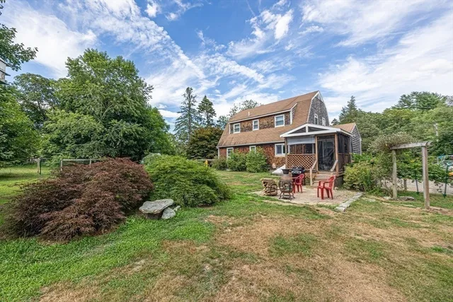 a view of a chair and table in backyard of the house