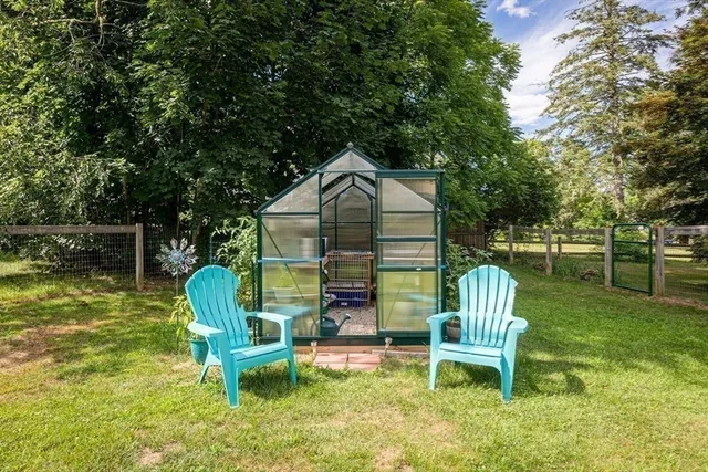 a view of a chair and table in back yard of the house