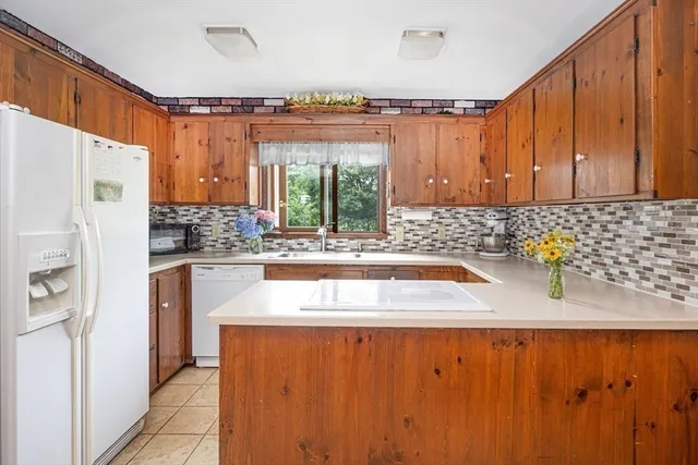 a kitchen with stainless steel appliances granite countertop a refrigerator a sink a stove and a microwave oven