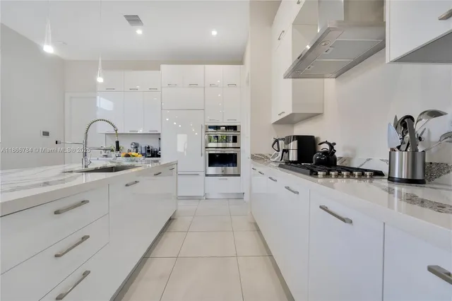 a large kitchen with stainless steel appliances granite countertop a sink and cabinets