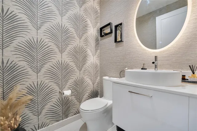 a bathroom with a sink mirror vanity and toilet