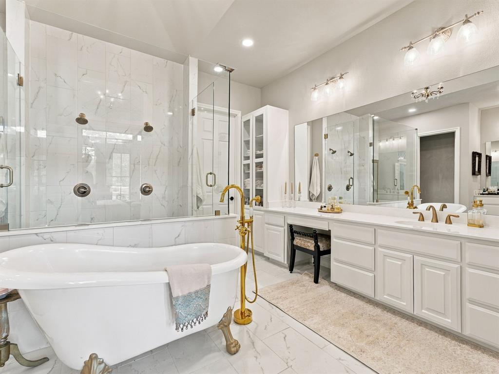 330 Rolling Bnd Road Alvord, TX 76225 - Photo 20 of 36 Freestanding bathtub with gold-finish fixtures, a spacious walk-in shower with multiple showerheads, dual vanities with expansive counter space, and integrated storage cabinetry