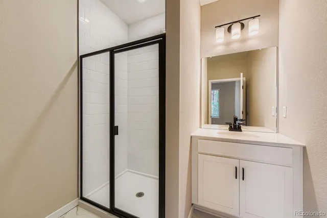 a bathroom with a shower sink and mirror