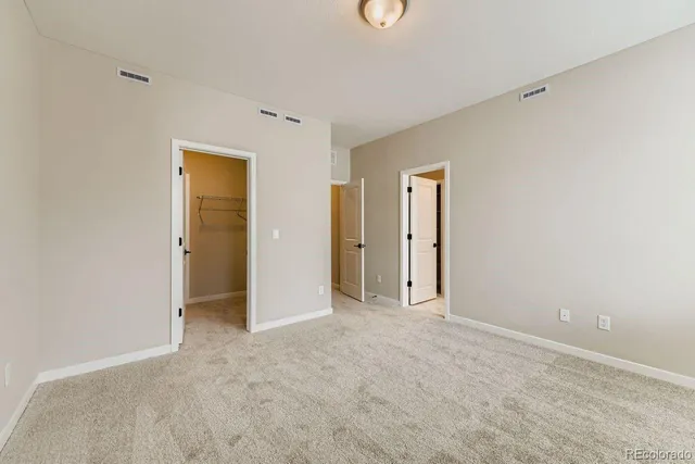 an empty room with closet and a window