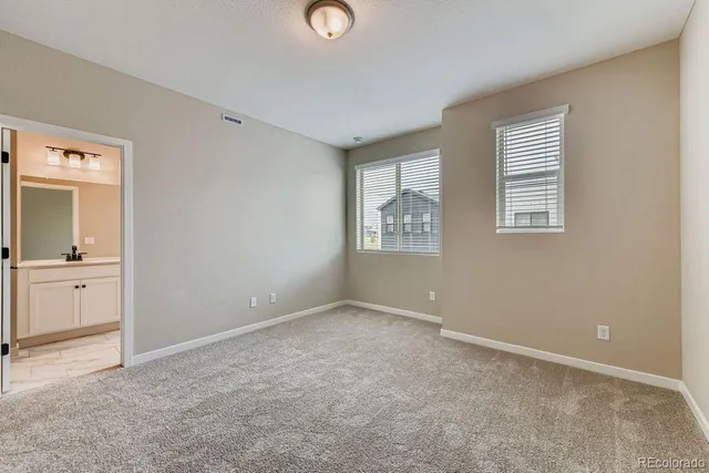 an empty room with windows and closet