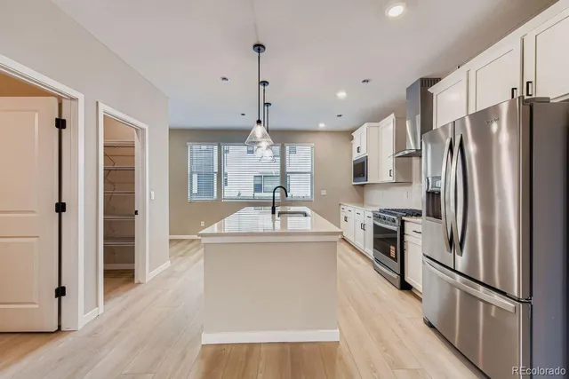 a kitchen with stainless steel appliances a refrigerator sink and stove