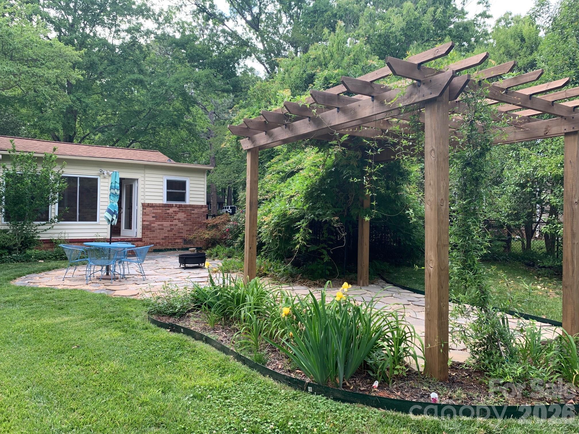 a view of a house with backyard and sitting area