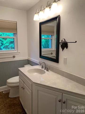 a bathroom with a toilet sink and mirror