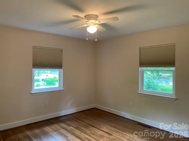 an empty room with window and a ceiling fan