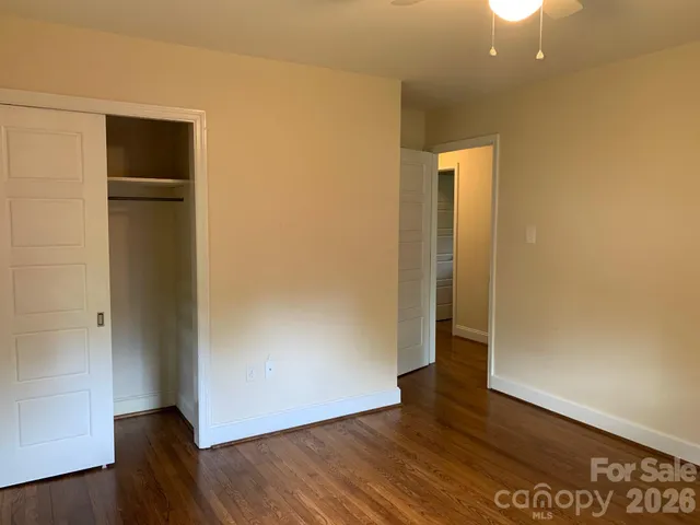 an empty room with wooden floor and closet