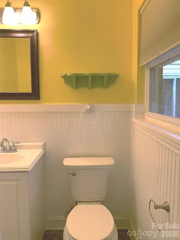 a bathroom with a toilet a sink and mirror