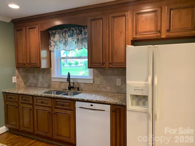 a kitchen with stainless steel appliances granite countertop a refrigerator and a sink
