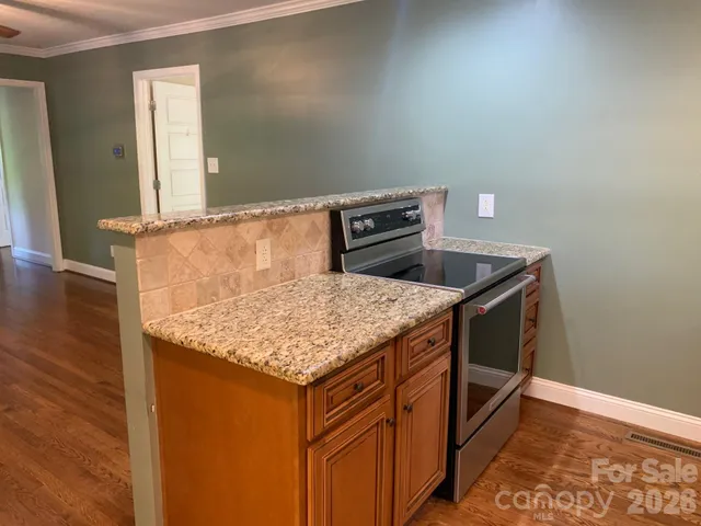 a kitchen with a sink a counter space and wooden floor