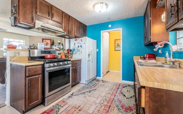 a kitchen with stainless steel appliances granite countertop a stove a washer and dryer