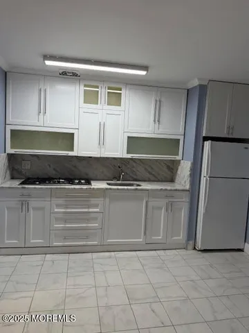 a kitchen with granite countertop a cabinets and a stove top oven